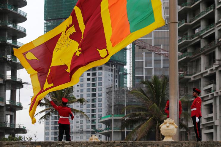 Sri Lankan army men lowers the national flag at the landmark Galle Face.