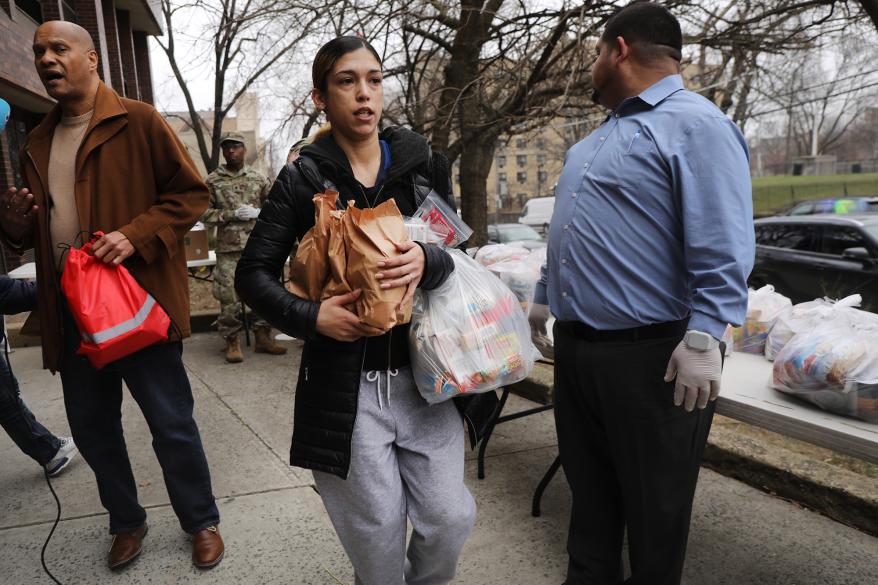 Residents receive bags of food from the National Guard near a one-mile radius “containment area”