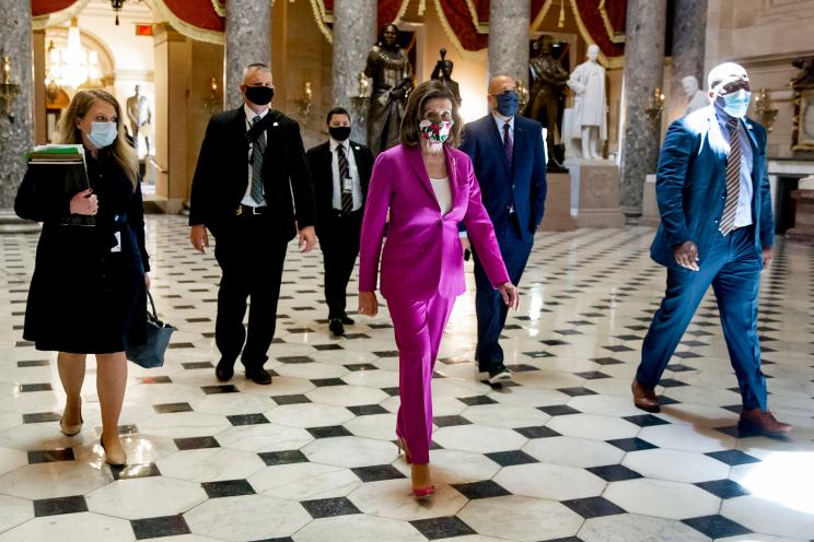 Speaker of the House Nancy Pelosi (C) walks from the House floor to her office