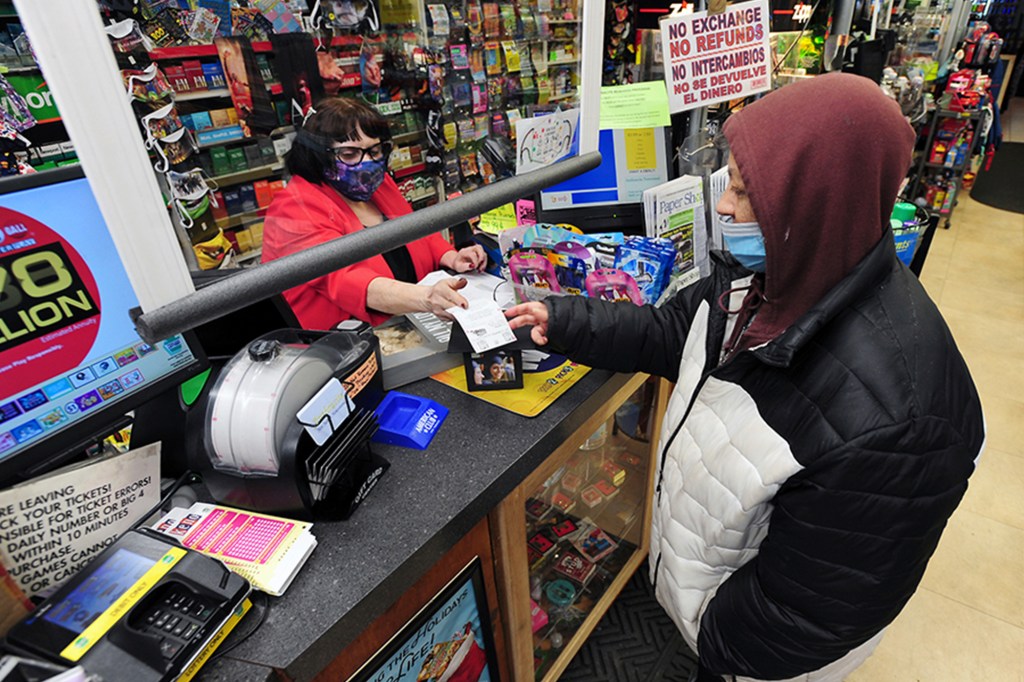 Jacqueline Donahue of Hazleton, right, buys la Mega Millions lottery ticket at the Anthracite Newsstand on Public Square