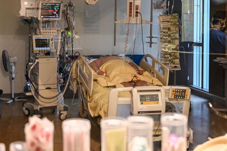 A patient stricken with COVID-19 lays in a hospital bed in Paris.