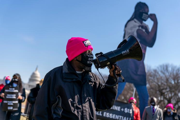 The Dome of the U.S. Capitol is visible during a $15 minimum wage rally held by One Fair Wage, advocates for restaurant workers, on the National Mall in Washington, Monday, Feb. 8, 2021.