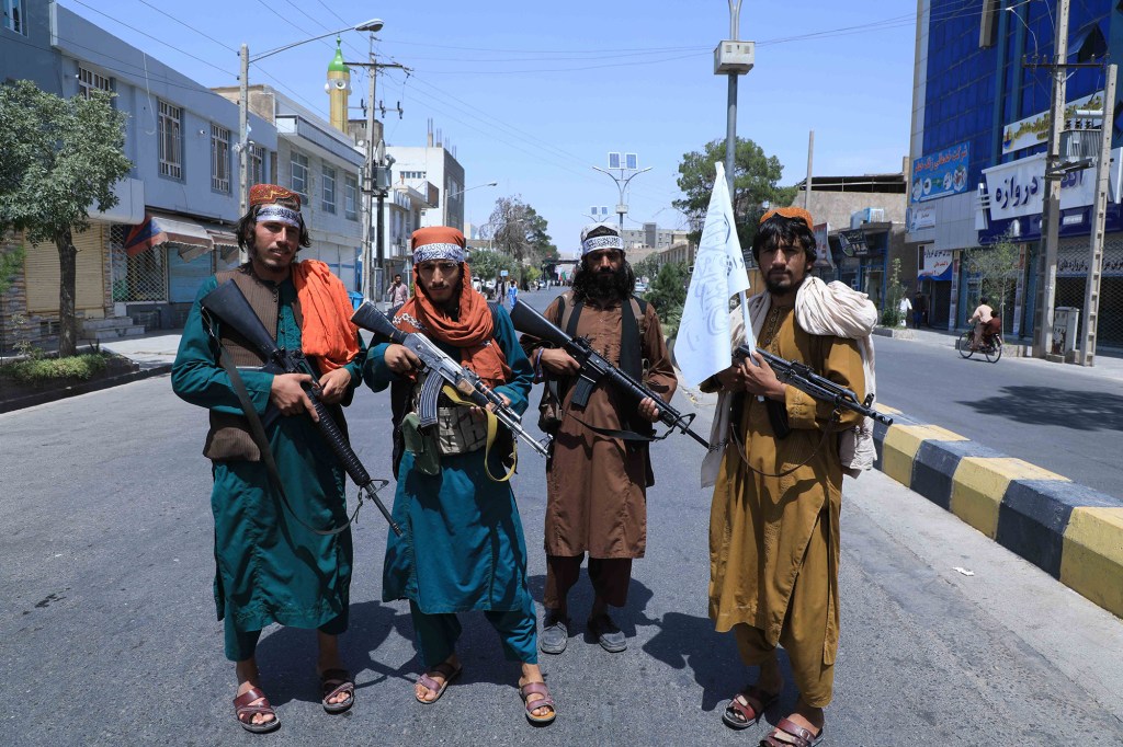 Four Afghan citizens holding guns.