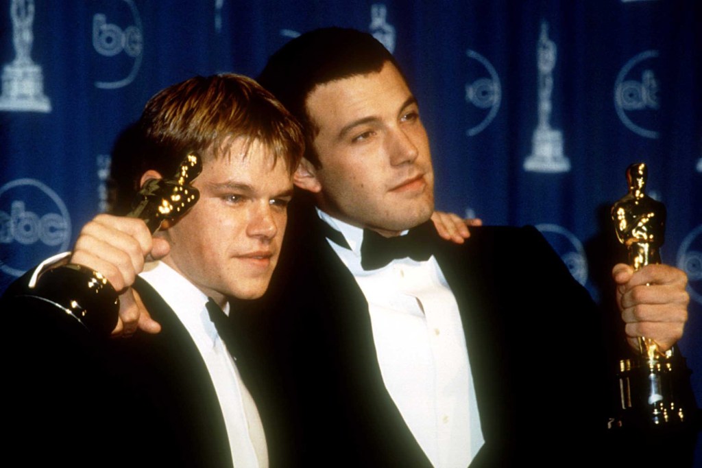 Matt Damon and Ben Affleck holding up their Oscars.