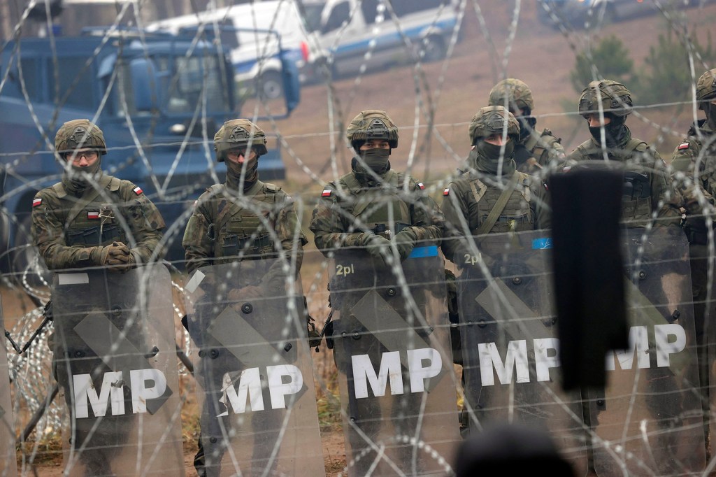 Polish servicemen guard an area near the barbed wire fence where migrants gather at the Belarus-Poland border near Grodno, Belarus.