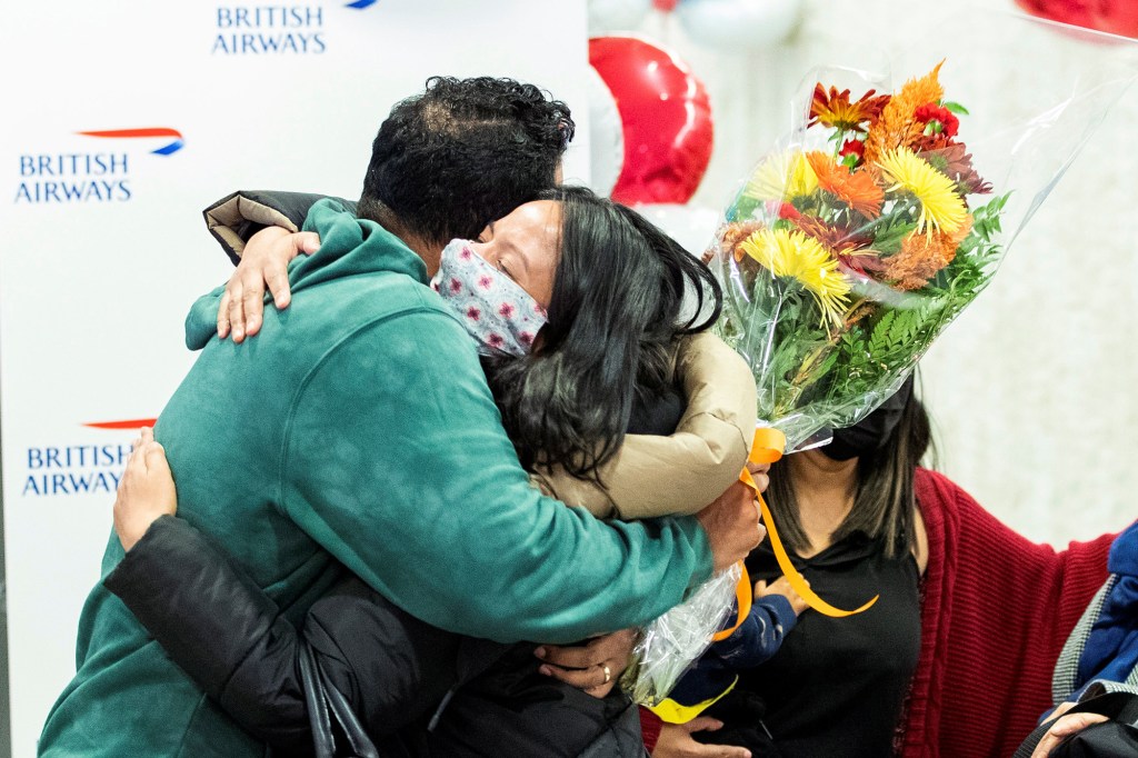 Family members hug each other as they are reunited after landing in the British Airways flight at JFK International Airport in New York, U.S., November 8, 2021