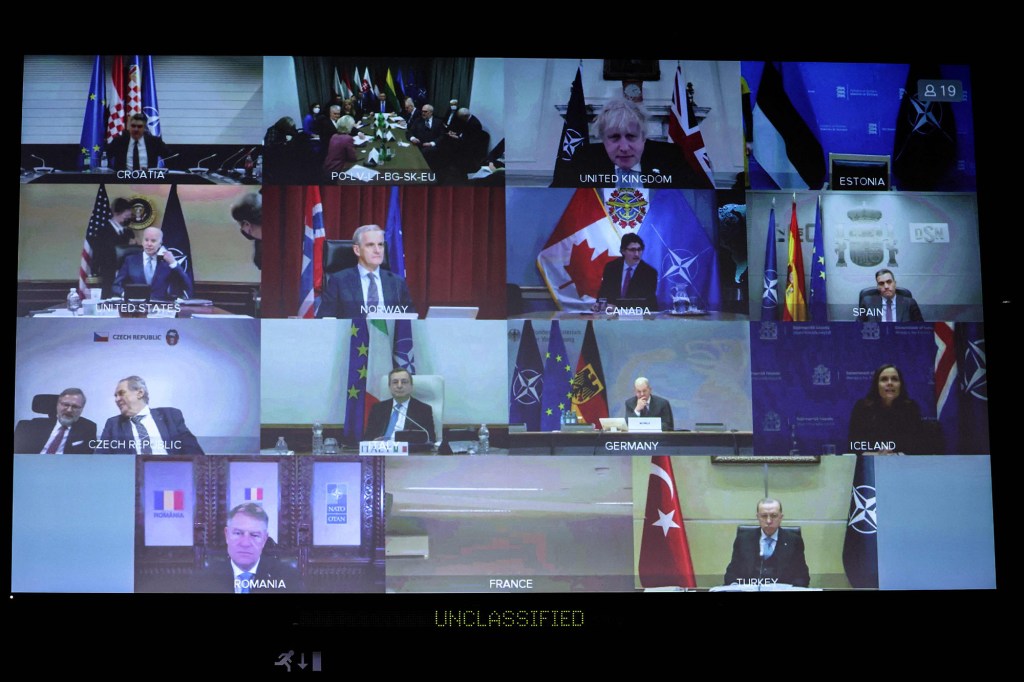 NATO leaders are seen on a screen as they attend a video summit on the Russian invasion of the Ukraine.