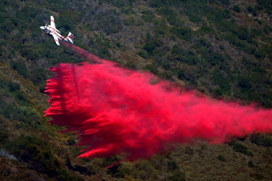 A plane drops fire retardant onto the Coastal Fire. The fire was first reported at a water treatment plant outside of Laguna Niguel and Laguna Beach around 2:45 P.M.