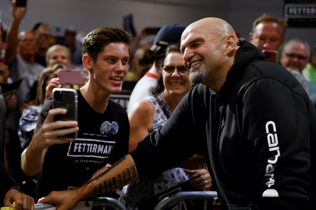 Fetterman poses for a photo with a supporter during his rally in Erie, Pa. He currently leads Oz by 8.7% points.