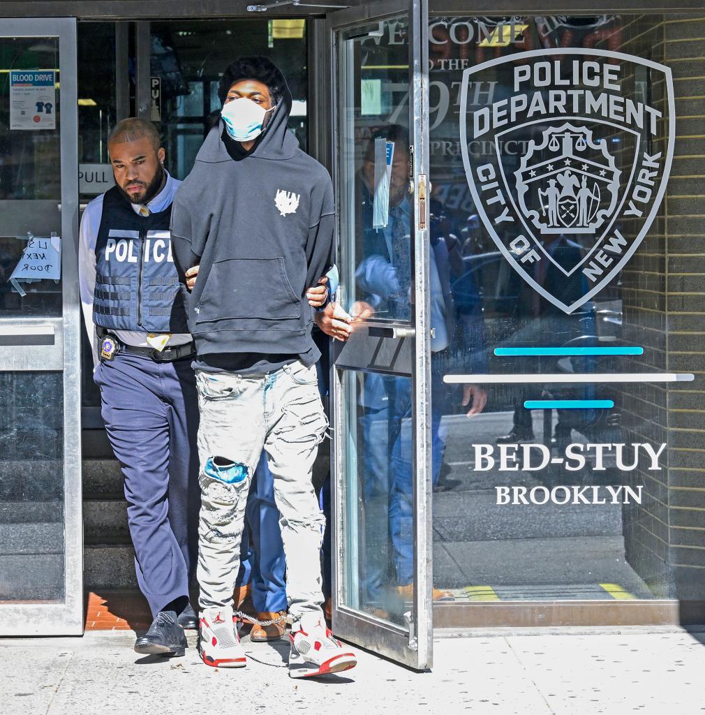 Shooting suspect Michael Morgan is escorted out of the 79th precinct in Brooklyn on Wednesday afternoon.