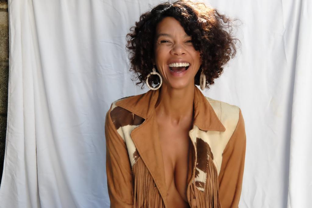 Jasmine Kenna laughs in a suede jacket.