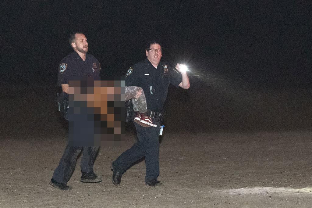 Police officers carry one of the 3 missing children