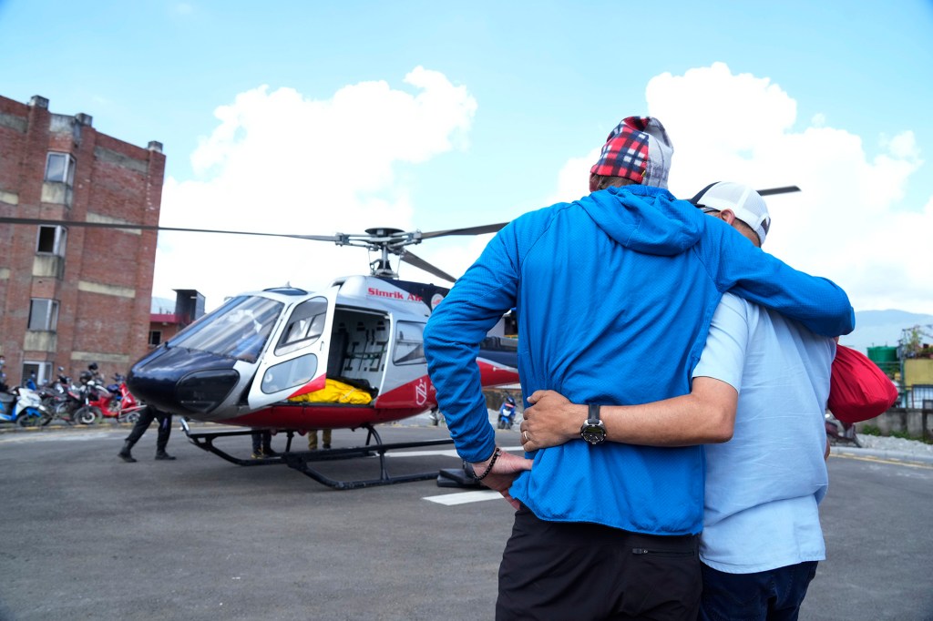 Jim Morrison, second right, mourns as Nelson's body arrives by helicopter in Kathmandu.