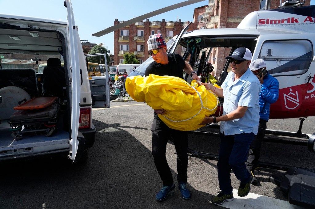 Jim Morrison carries the body of his partner and famed U.S. extreme skier, Hilaree Nelson, from a helicopter at a hospital in Kathmandu, Nepal, Wednesday, Sept. 28, 2022.