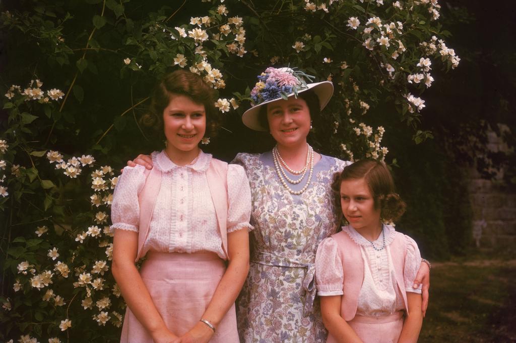 Then Princess Elizabeth II with her mother Queen Elizabeth and Princess Margaret by a syringa bush at Windsor Castle, Berkshire on July 8, 1941.