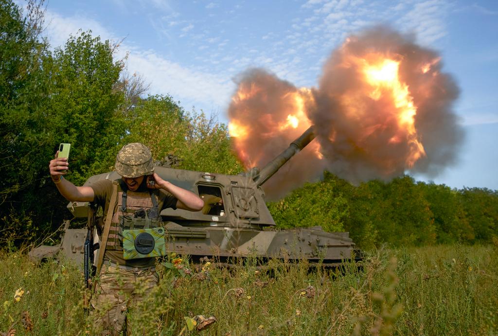 A Ukrainian soldier takes a selfie as an artillery system fires in the front line in Donetsk region, eastern Ukraine.