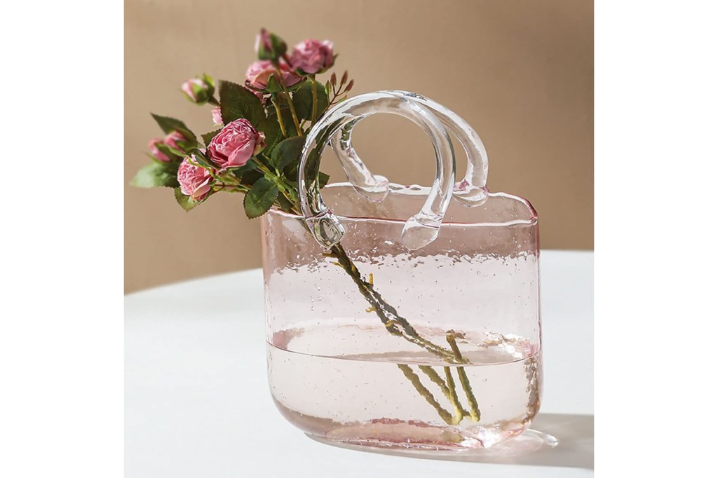 A glass vase shaped like a purse