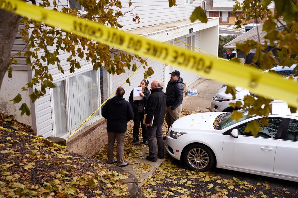 Investigators pictured outside the home where the students were slain. Cops continue to search for a suspect.