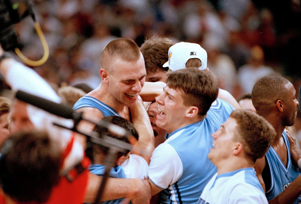 North Carolina's Eric Montross, left, gets mobbed by cheerleaders and fans after the Tar Heel beat Michigan 77-71 to win the national championship Monday in New Orleans, LA., April 5, 1993.