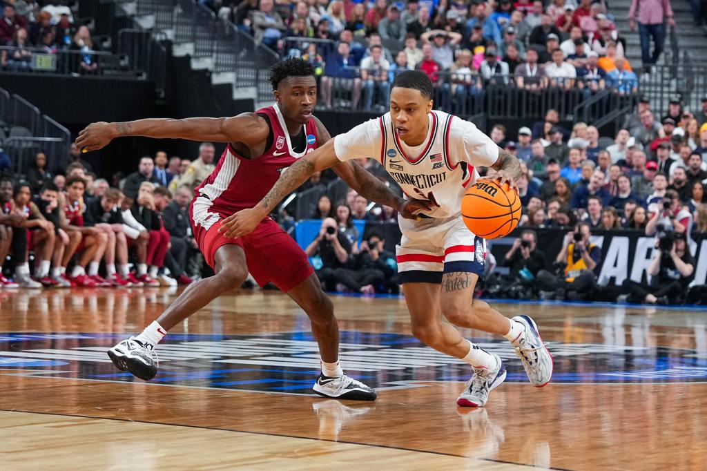 Jordan Hawkins moves the ball past Davonte Davis of the Arkansas Razorbacks during the Sweet Sixteen round.