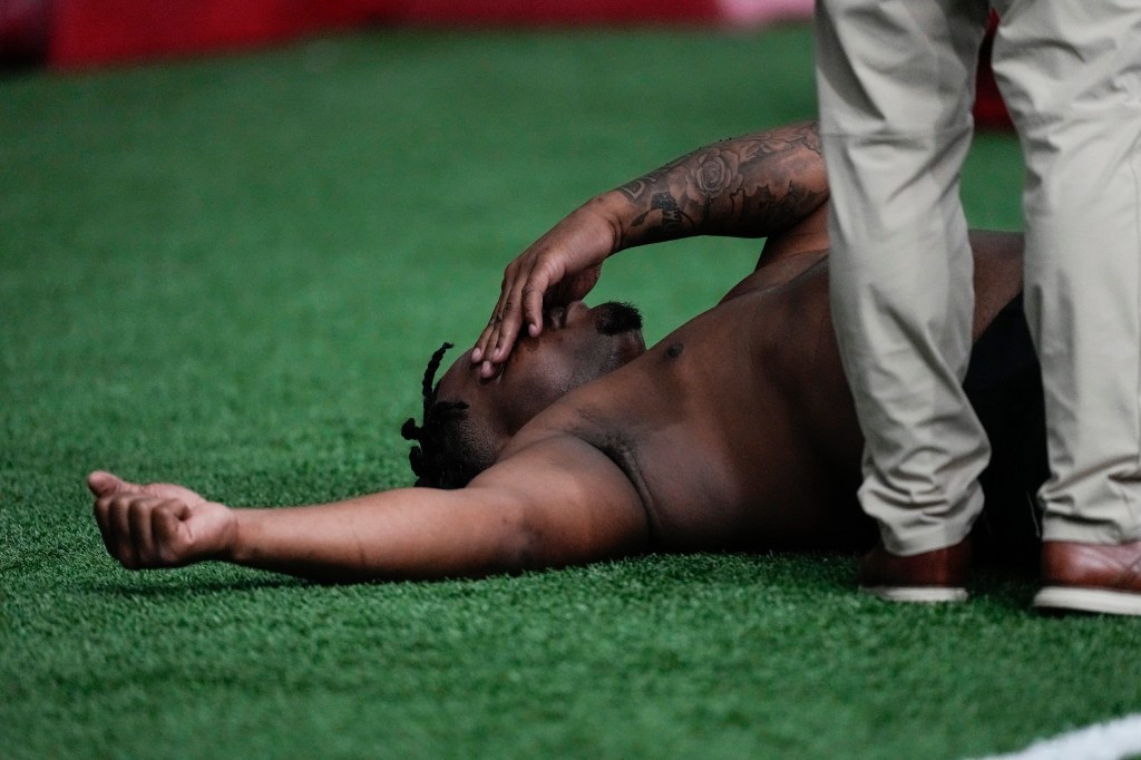 A trainer works with former Georgia defensive lineman Jalen Carter after he runs football drills during Georgia's Pro Day, on March 15, 2023, in Athens, Ga.  