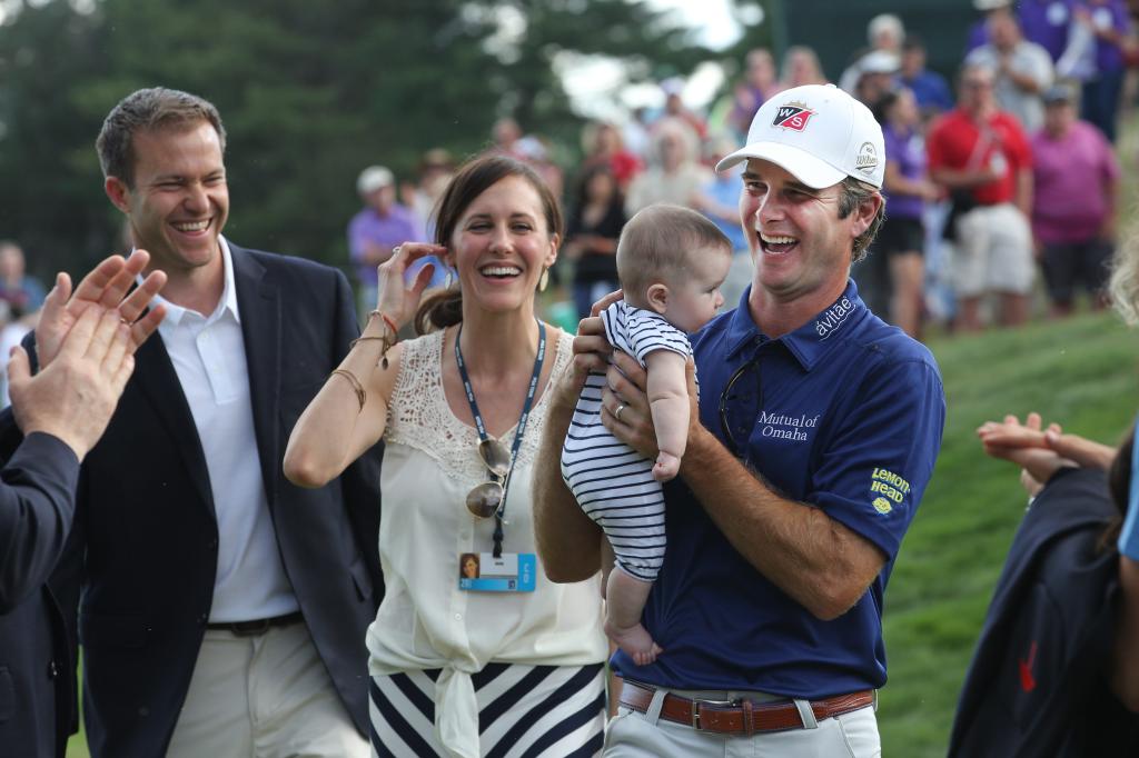 Kevin Steelman holding his baby daughter Sophia and standing with wife Courtney