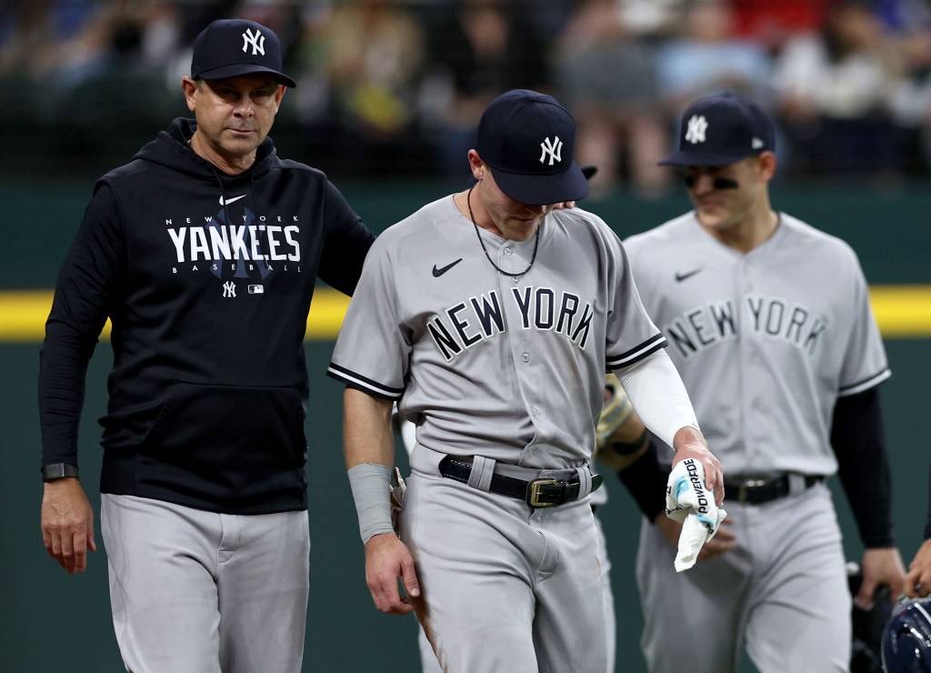 Jake Bauers slowly walks off the field with Aaron Boone after suffering an injury when he made a diving catch during the first inning of the Yankees-Rangers game.