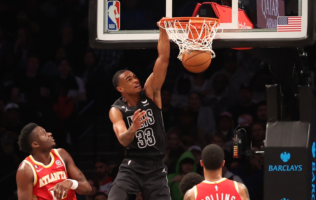 Nic Claxton slams the ball in front of Clint Capela and John Collins of the Hawks.