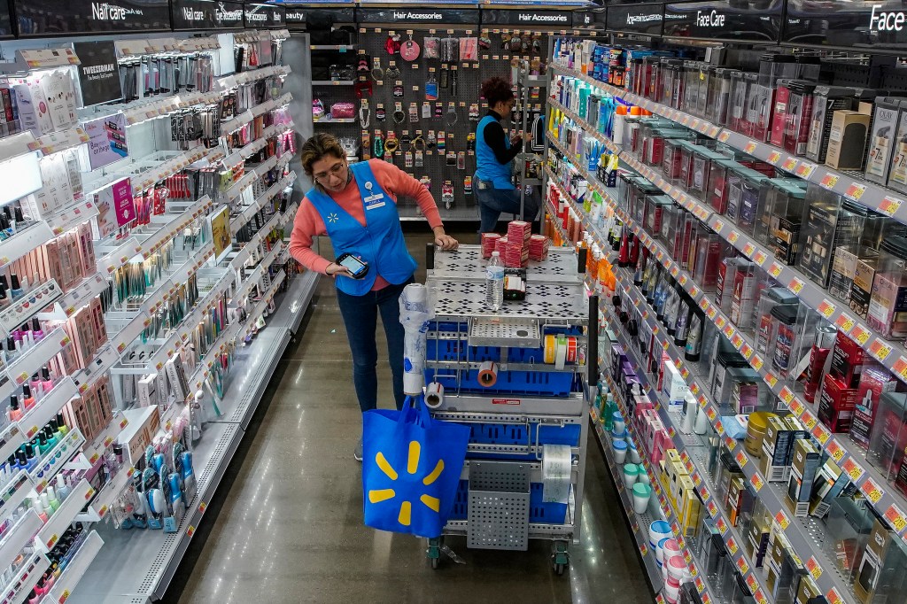 A Walmart employee organizes beauty products.