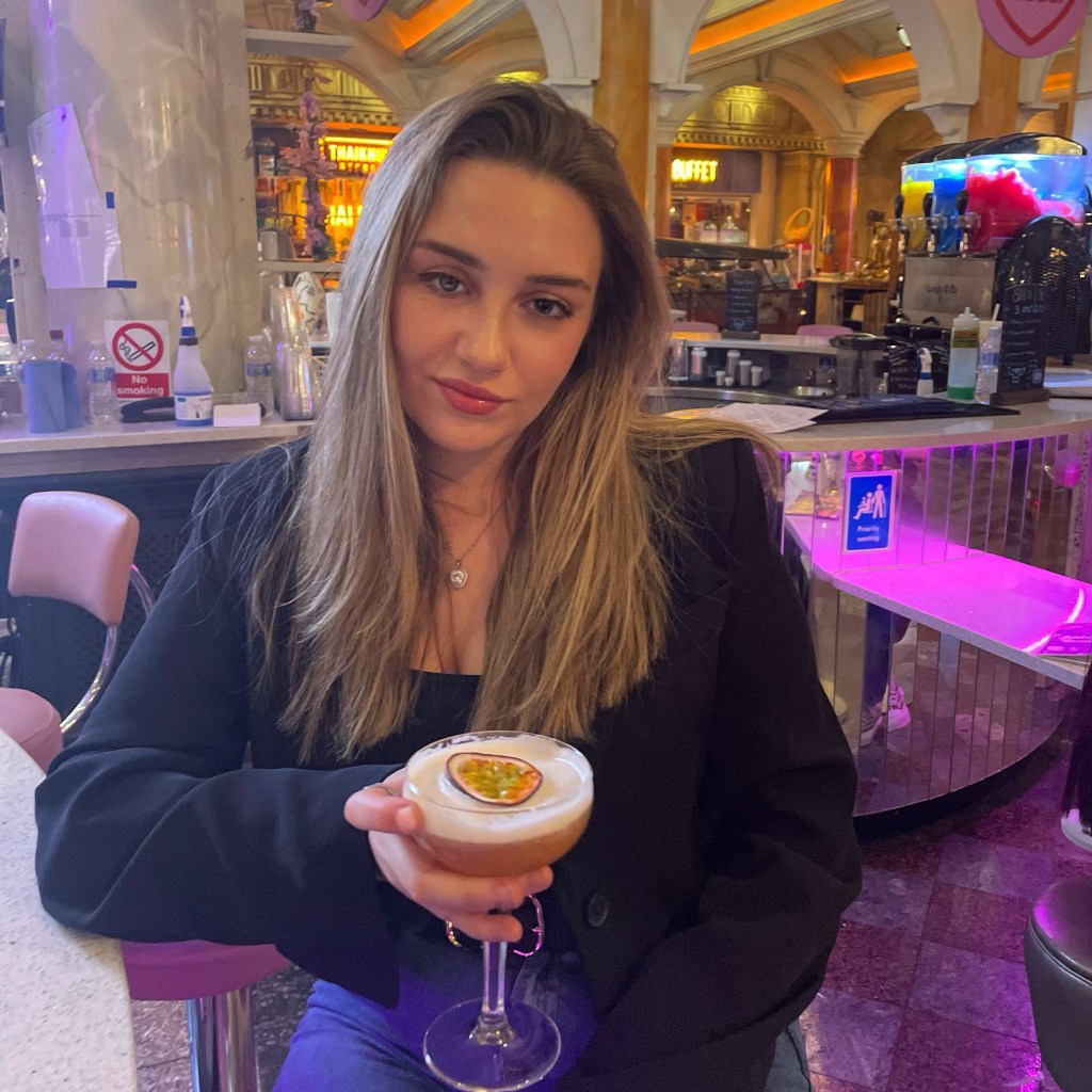 Blonde woman holding cocktail.