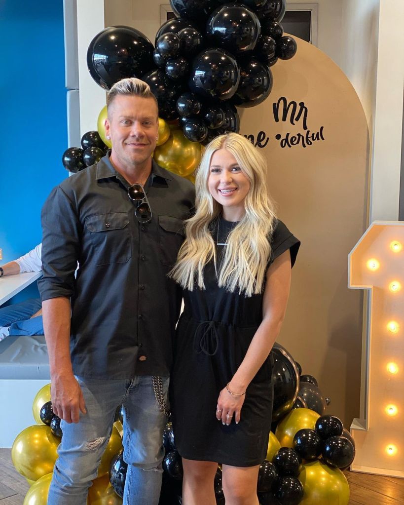 Man and woman standing in front of balloons.