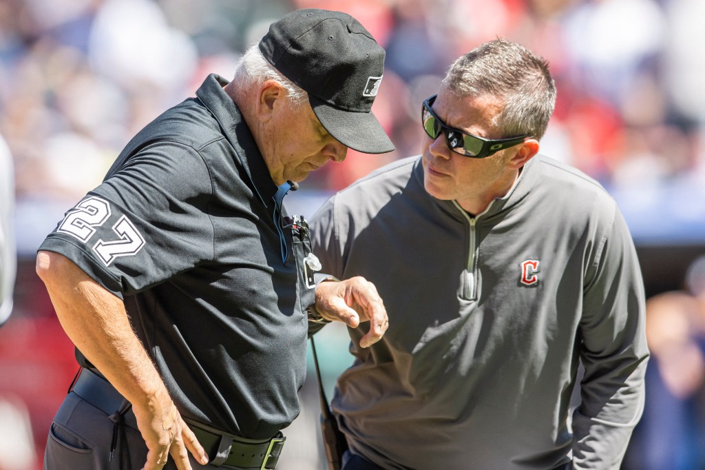 A Guardians trainer tends to umpire Larry Vanover after he was struck in the head with a throw on April 12, 2023.