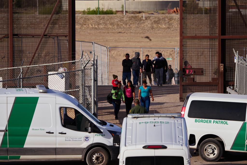 U.S. Customs and Border Protection officers transport migrants for processing.