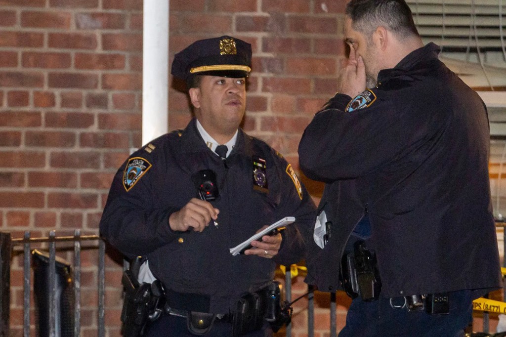 Police gather at the scene of the shooting on the grounds of the St. Nicholas Houses.