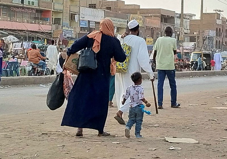 People gather to ride a truck to flee outside Khartoum.