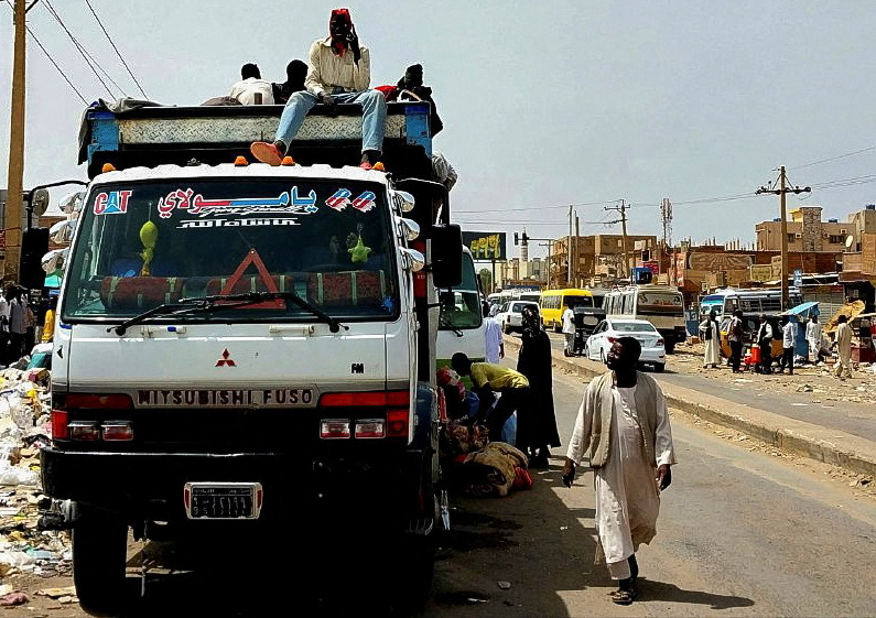 People trying to hitch ride on truck in Sudan