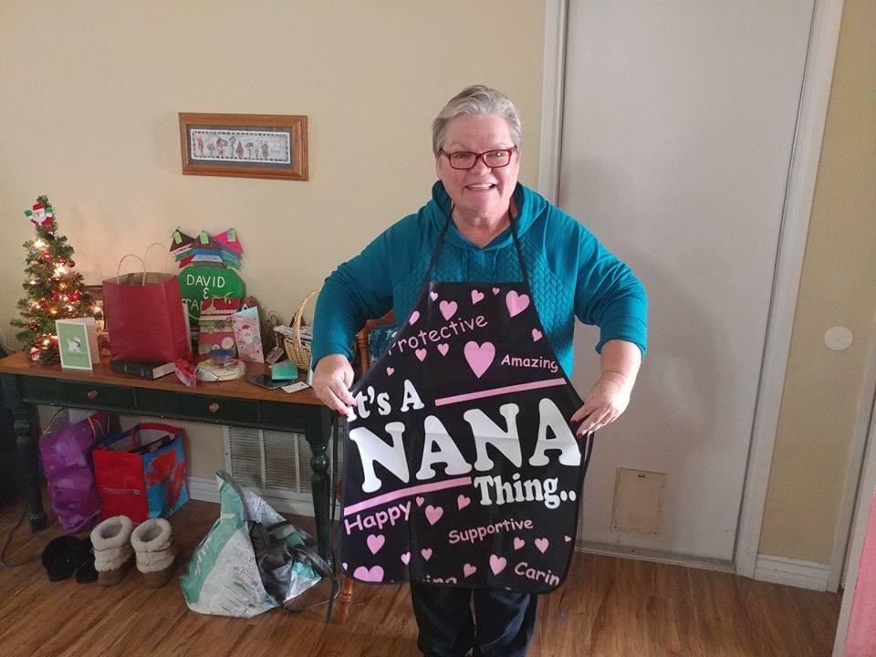 Tammy Fertig wearing an apron that says "It's a nana thing." 