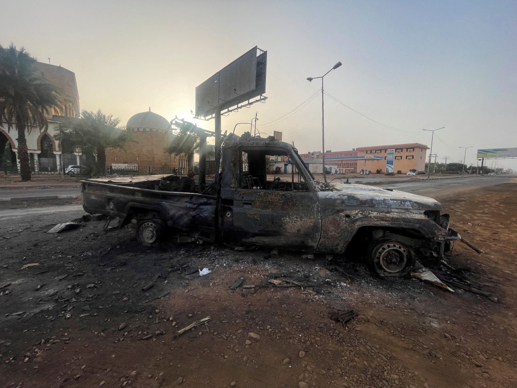 A burned vehicle is seen in Khartoum.