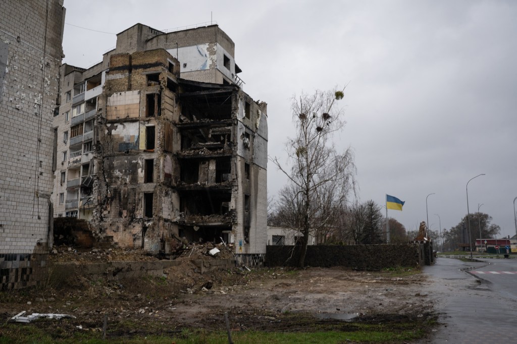 A destroyed building is seen in Borodyanka next to a Ukrainian flag on April 9, 2023. 