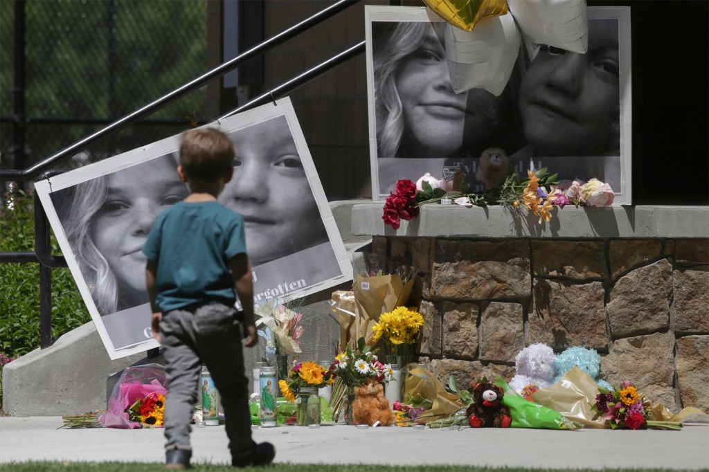 A boy looks at a memorial for Tylee Ryan and Joshua "JJ" Vallow in Rexburg, Idaho.