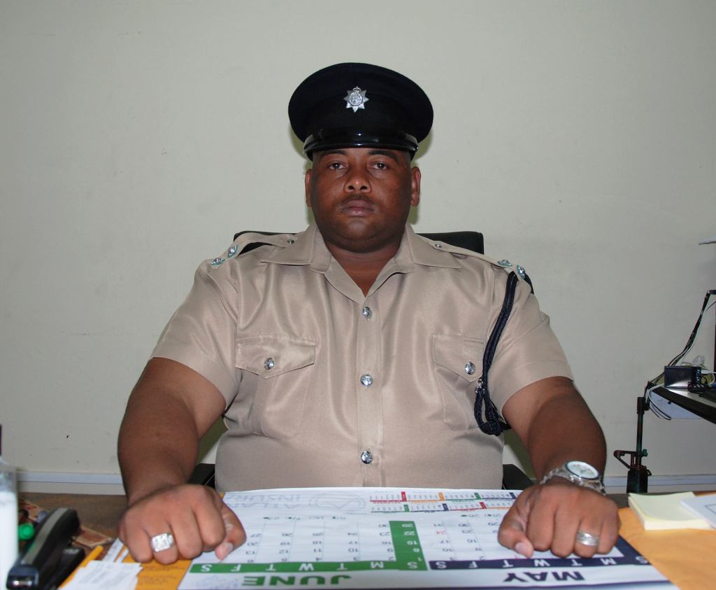 Henry Jemmott sits behind a desk in uniform.