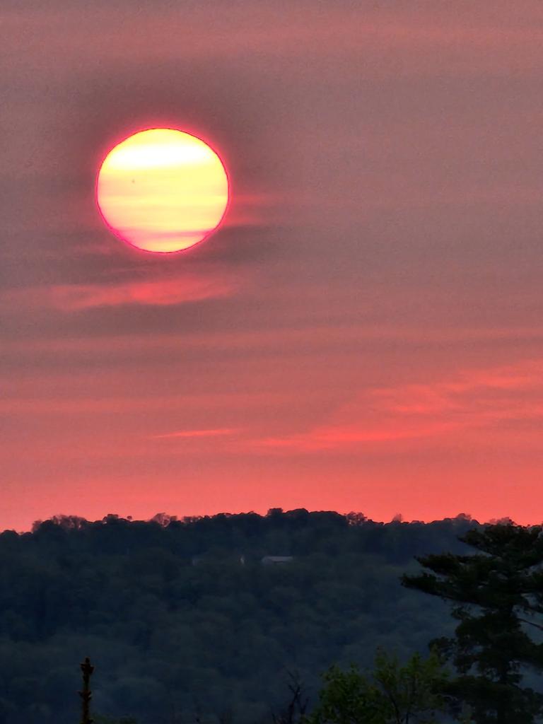 The sunrise, featuring a sunspot exposed by the hazy conditions, rose over New York's Finger Lakes Monday.