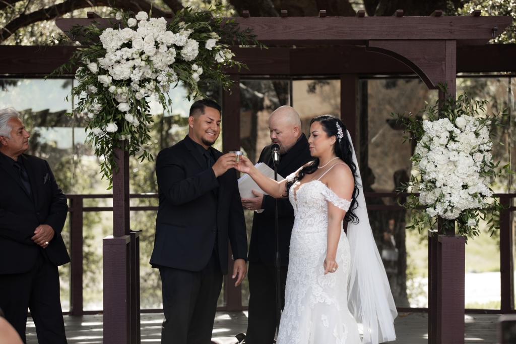 Armando Quiroz and Kristina Quiroz taking a shot at the altar during their April 2023 wedding in Temecula, California. 