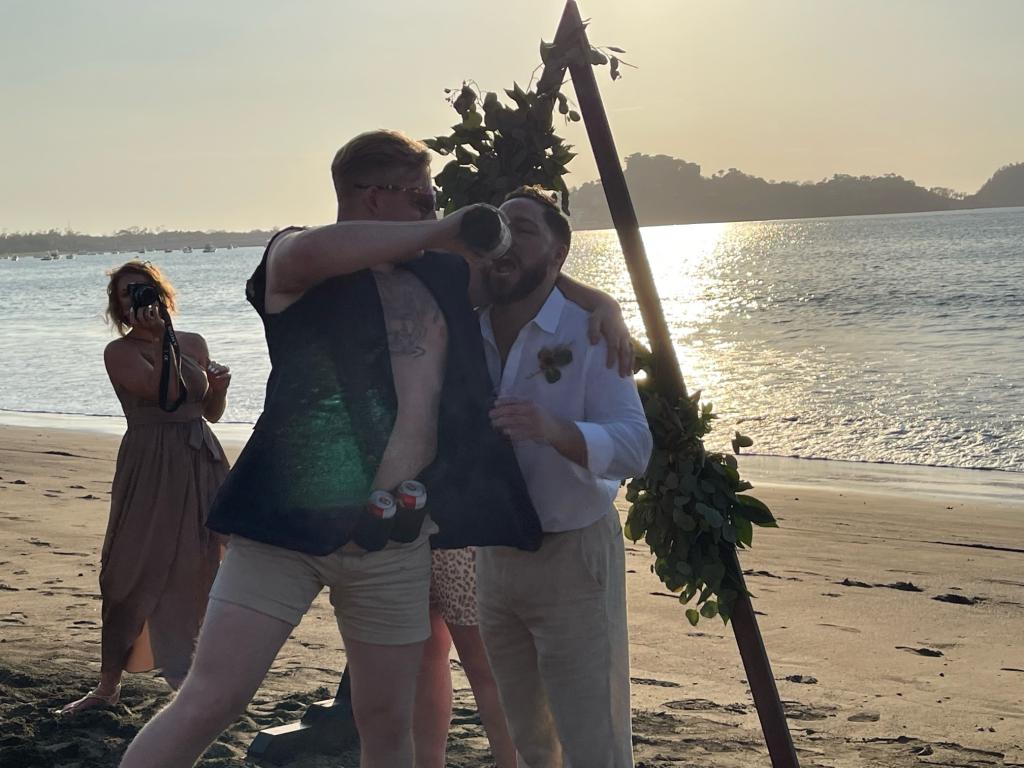 Austin Hoyt (left) pouring a shot into Austin Tompkins' mouth during Tompkins' March 3, 2023 destination wedding in Costa Rica. 