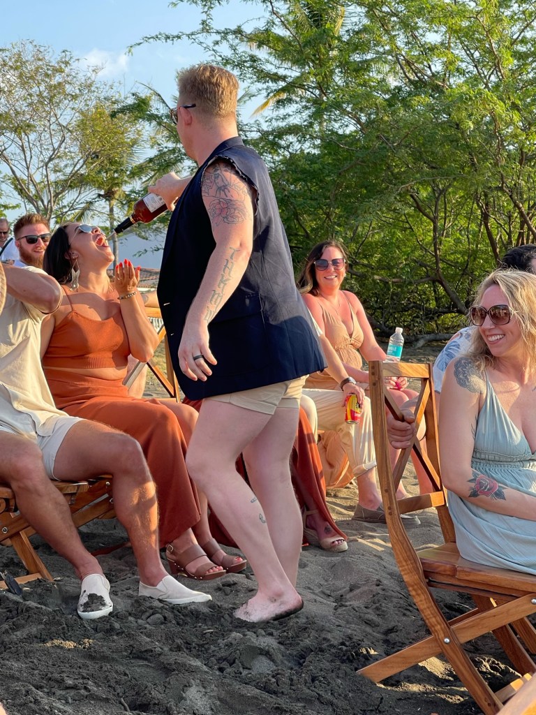 Austin Hoyt pouring pre-mixed vodka shots in wedding guests' mouths at Austin and Aleah Tompkins' March 3, 2023 destination wedding in Costa Rica. 