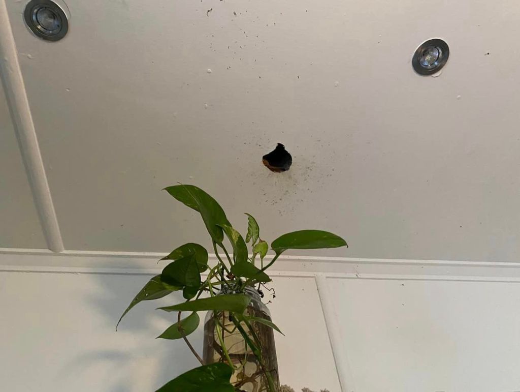 A hole in the ceiling caused by the explosion resulting from the heated can of Glen20.