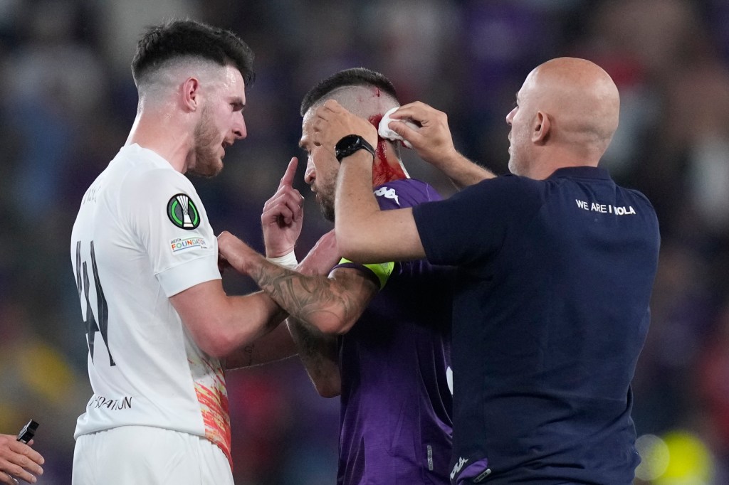 Fiorentina's Cristiano Biraghi is treated after being hit by an objec