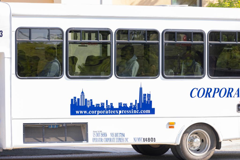 Migrant getting on a bus at the Crossroads Hotel after arriving.