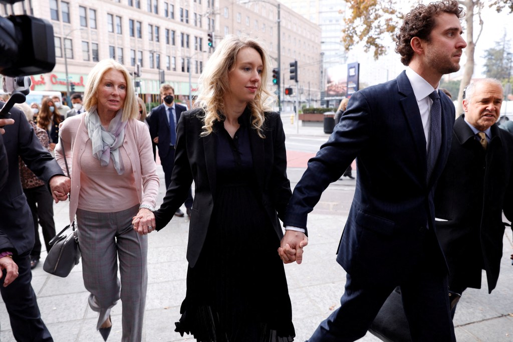 Theranos founder Elizabeth Holmes walks to her sentencing last year with her family and partner Billy Evans.