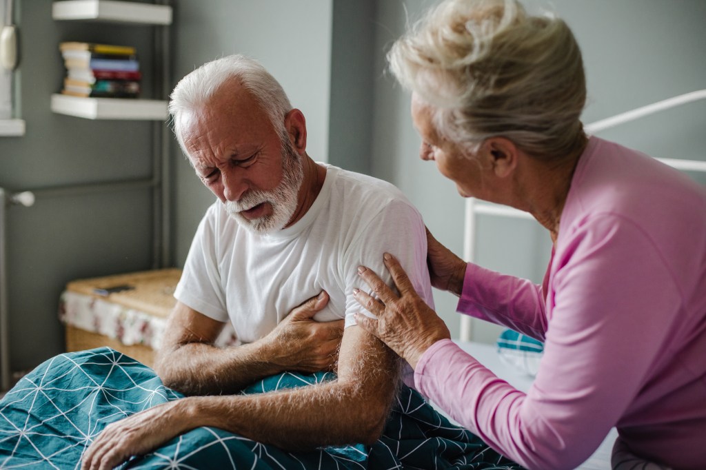 Senior man suffering from a heart attack at home